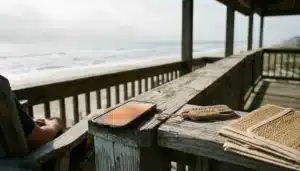 Smartphone glowing on a beach rental porch railing, symbolizing vacation hashtags driving direct bookings